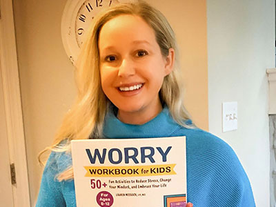 Lauren Mosback holding her Worry Workbook for Kids